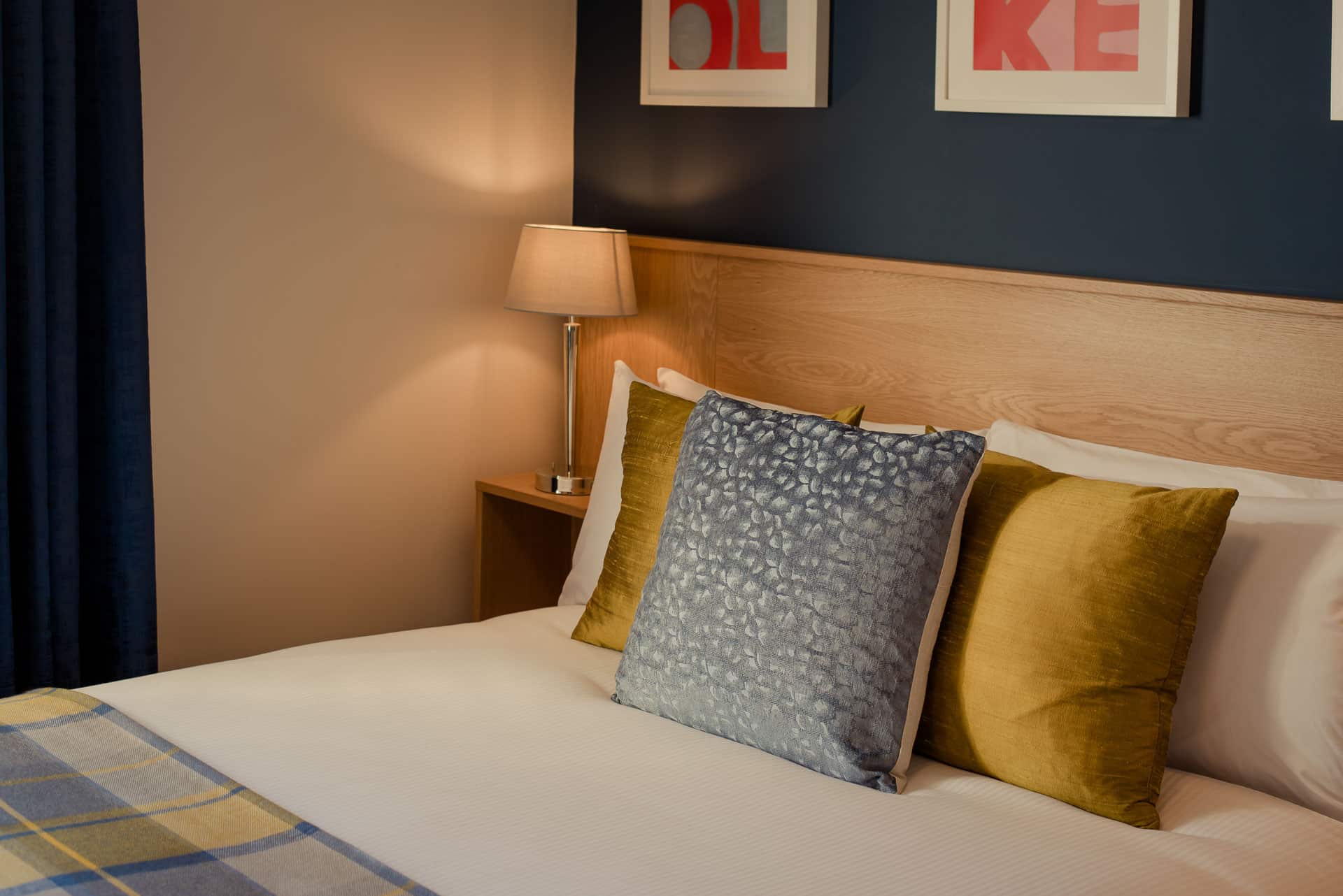 Twin beds with striped cushions and wall art above.